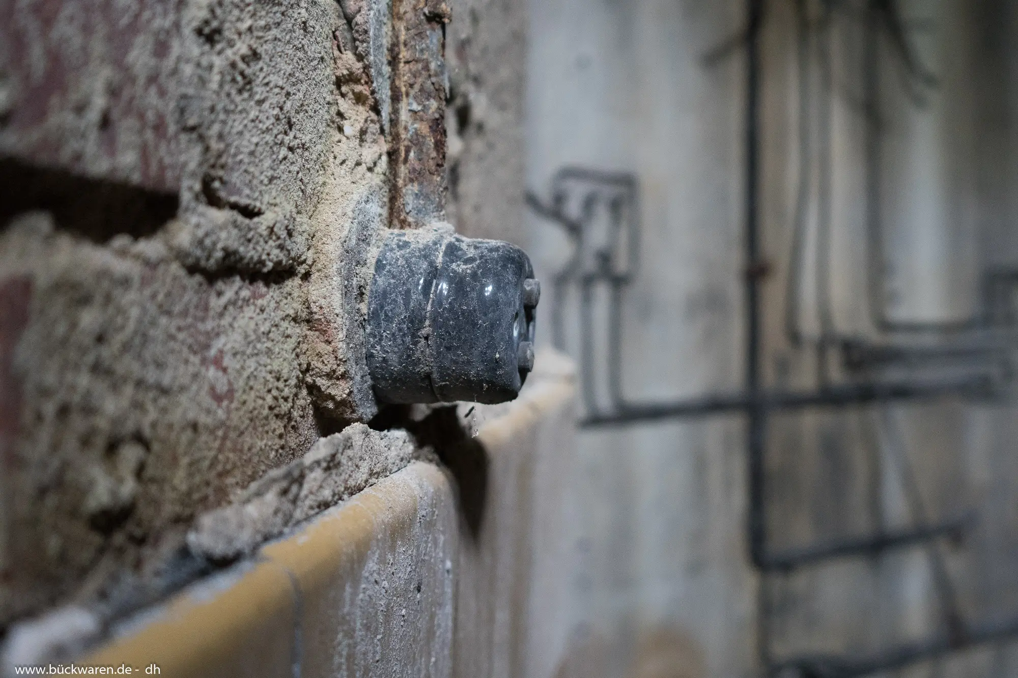 Porzellan an der Wand, Leitungen als Schatten.