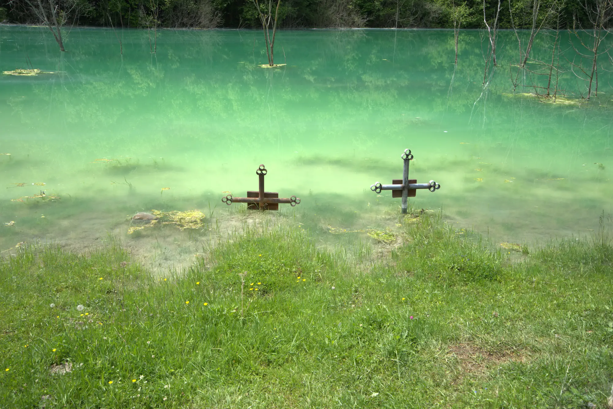 Zwei Kreuze im Grün. Der Friedhof liegt darunter.