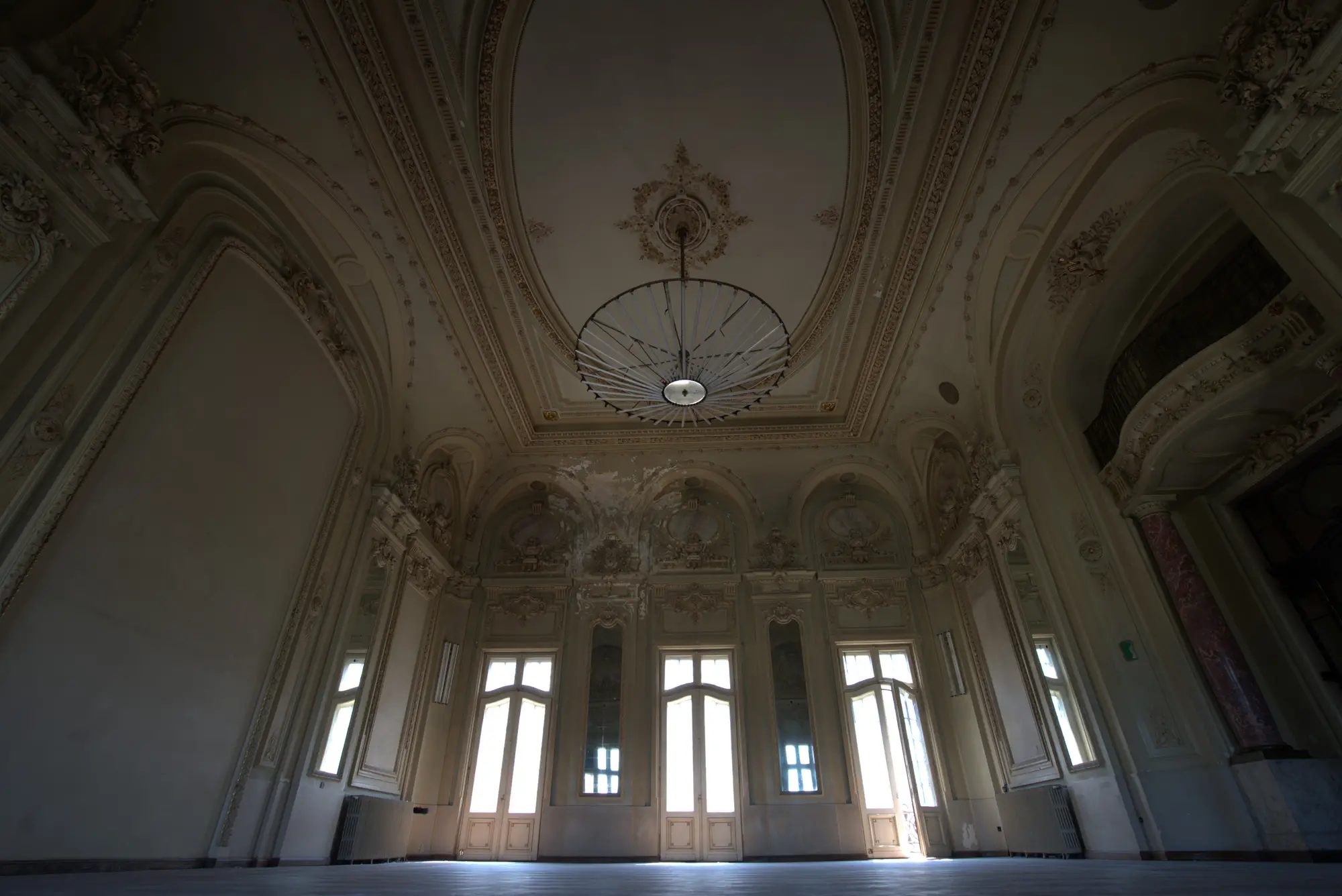Ein Ballsaal in Weiß. Der Leuchter hängt noch.