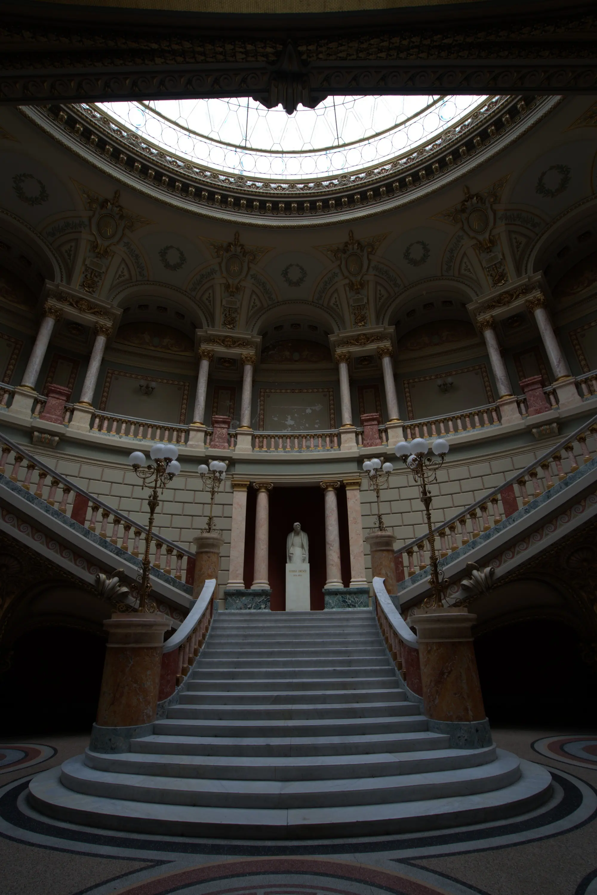 Die Treppe unter der Kuppel. Oben steht einer aus Stein.